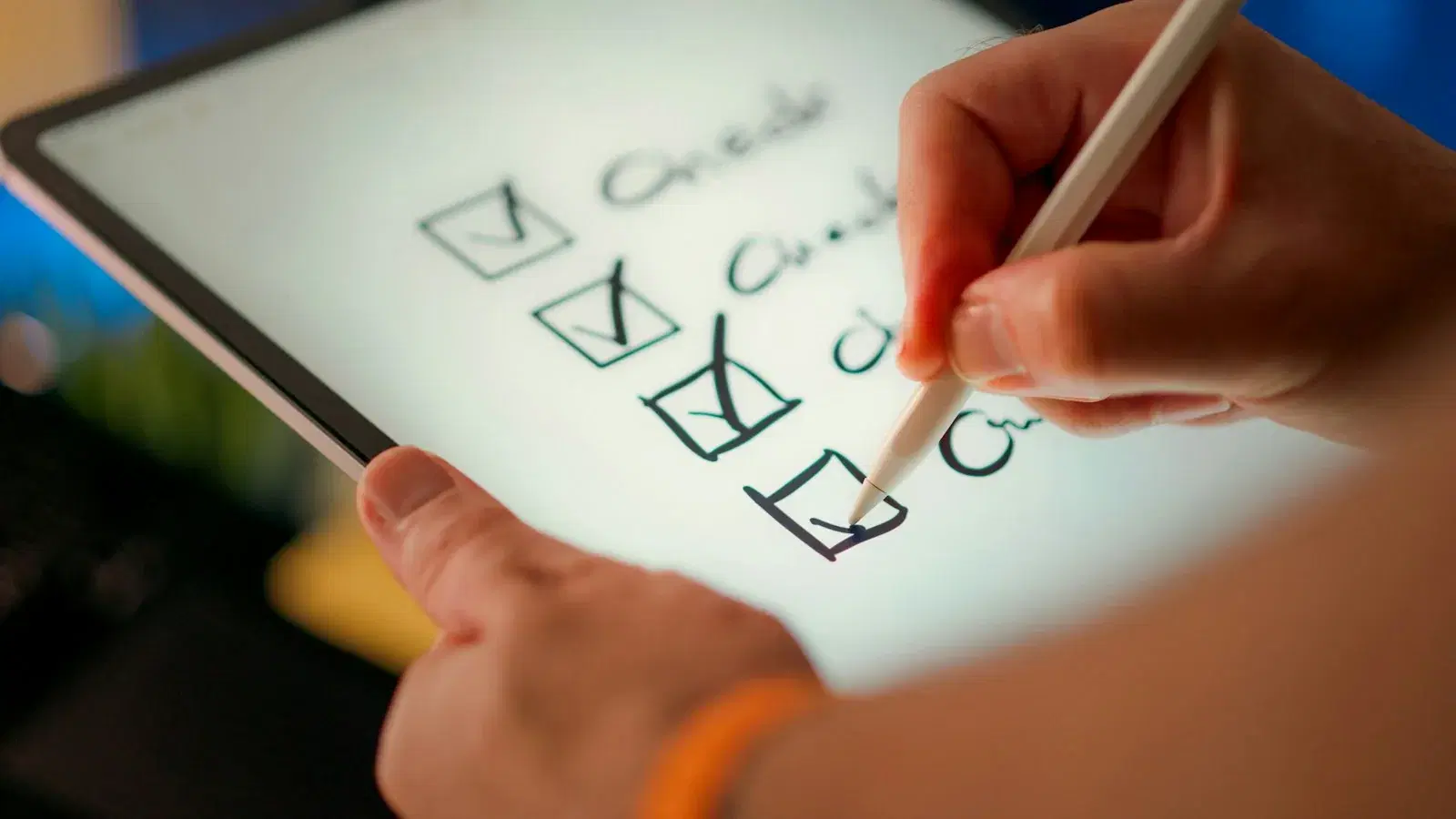 A hand ticking a column of checkboxes on a tablet with a stylus.
