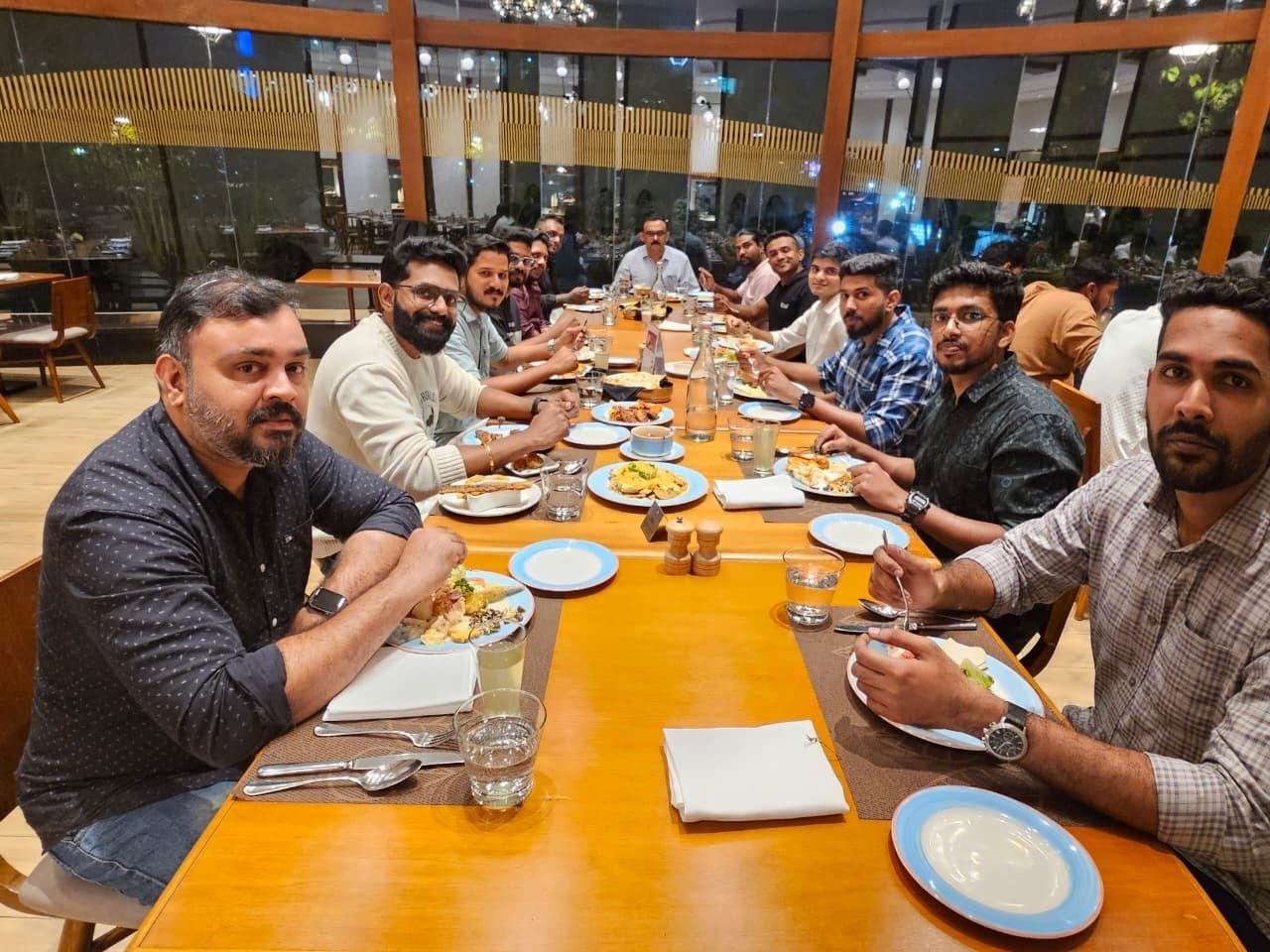 The iLeaf team eating together around one long table in the evening