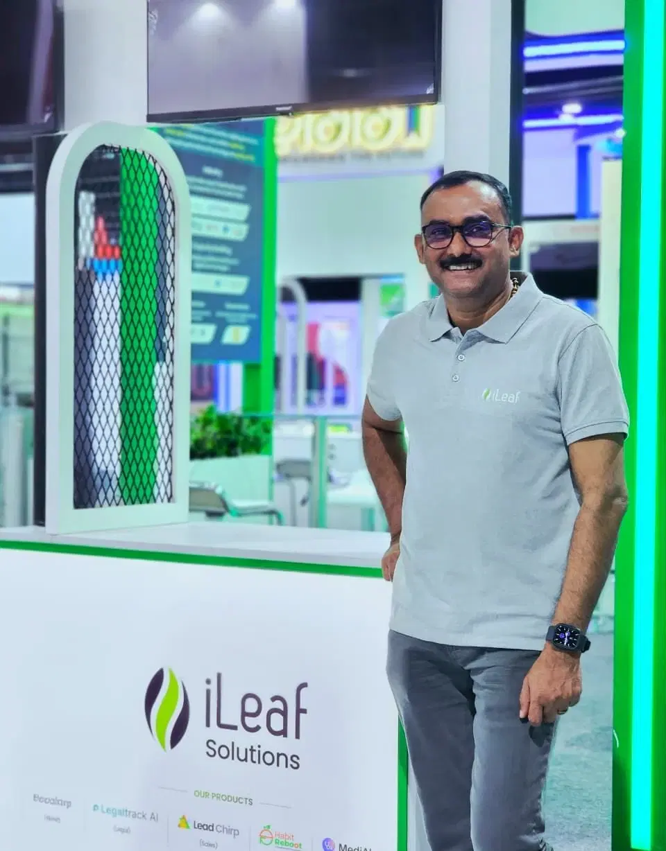 Jaison Joseph at the iLeaf Solutions stand, beside a banner listing the company's own products
